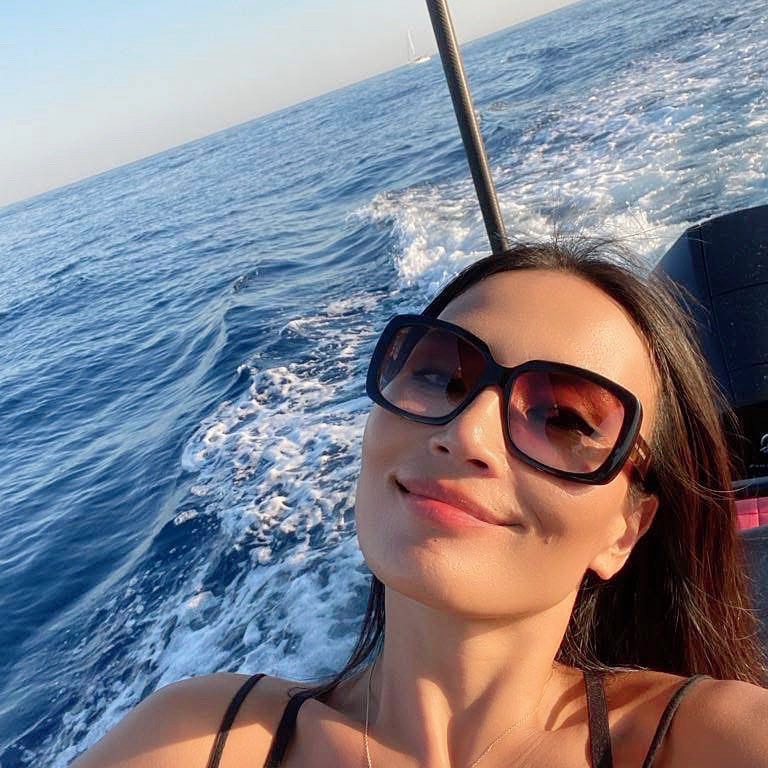 Routine coréenne peau sensible : femme souriante en vacances d’été, en mer, profitant du soleil avec une peau protégée